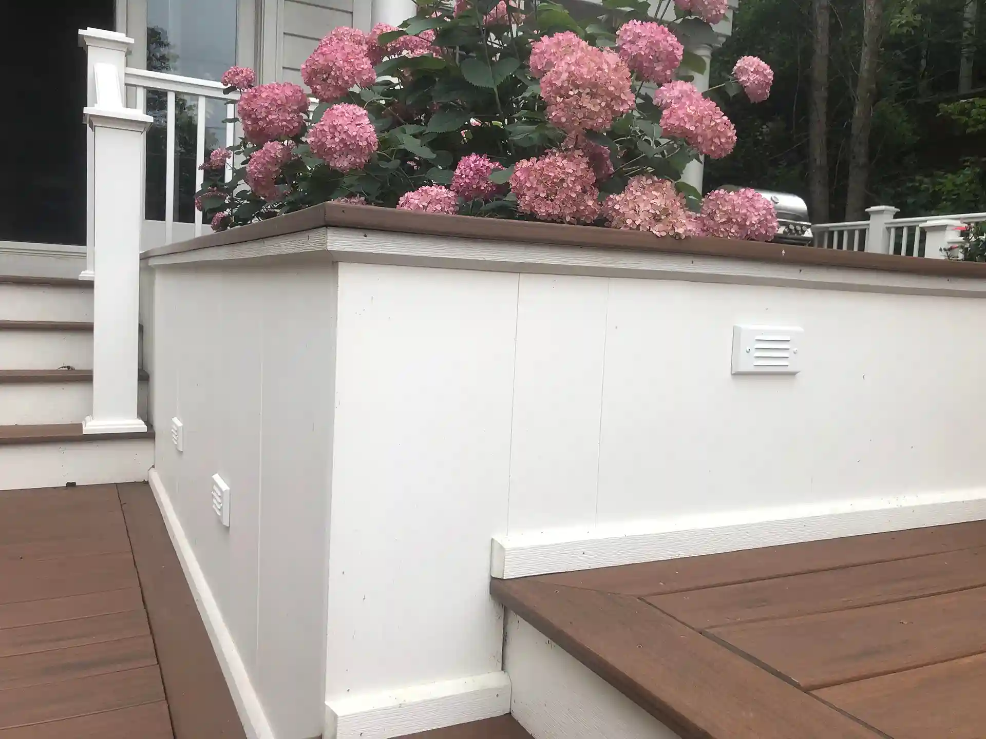 photo of a multi-level composite deck with built-in planter box and grilling station 