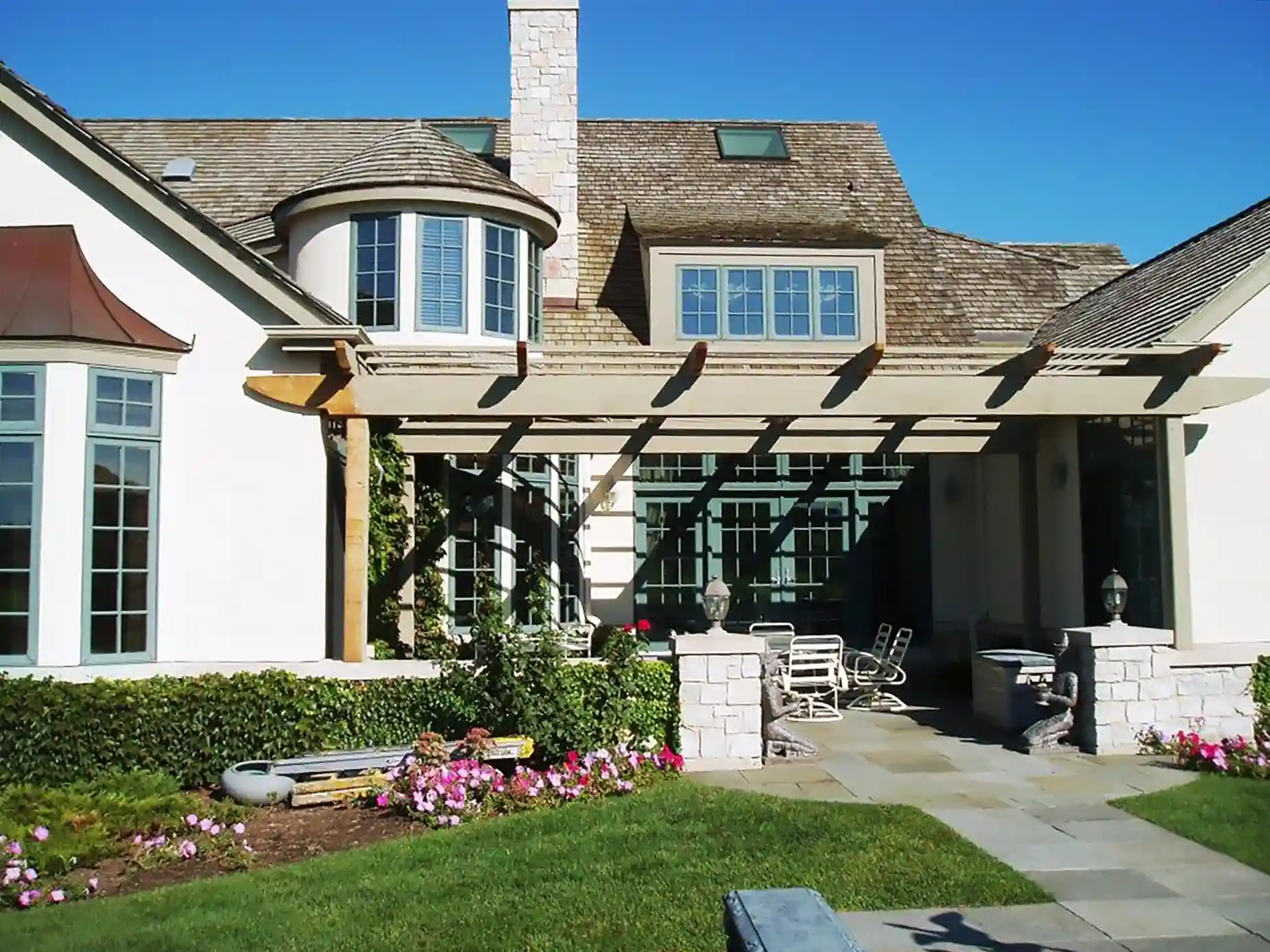 House with a pergola-covered patio and garden.
