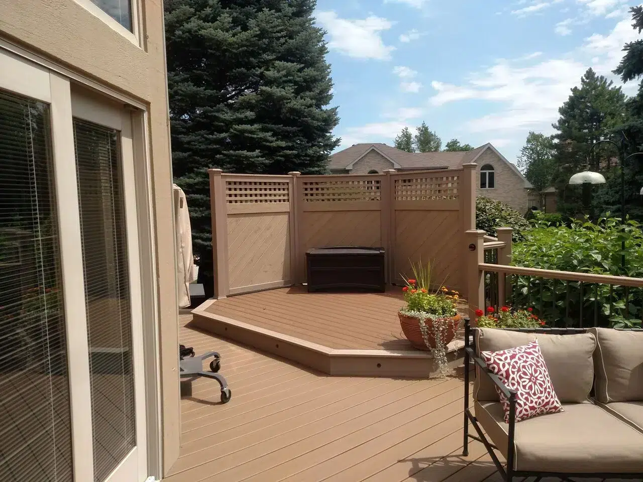Photo of a multi-level deck with an angled overlook area, geometric designs, and a pergola
