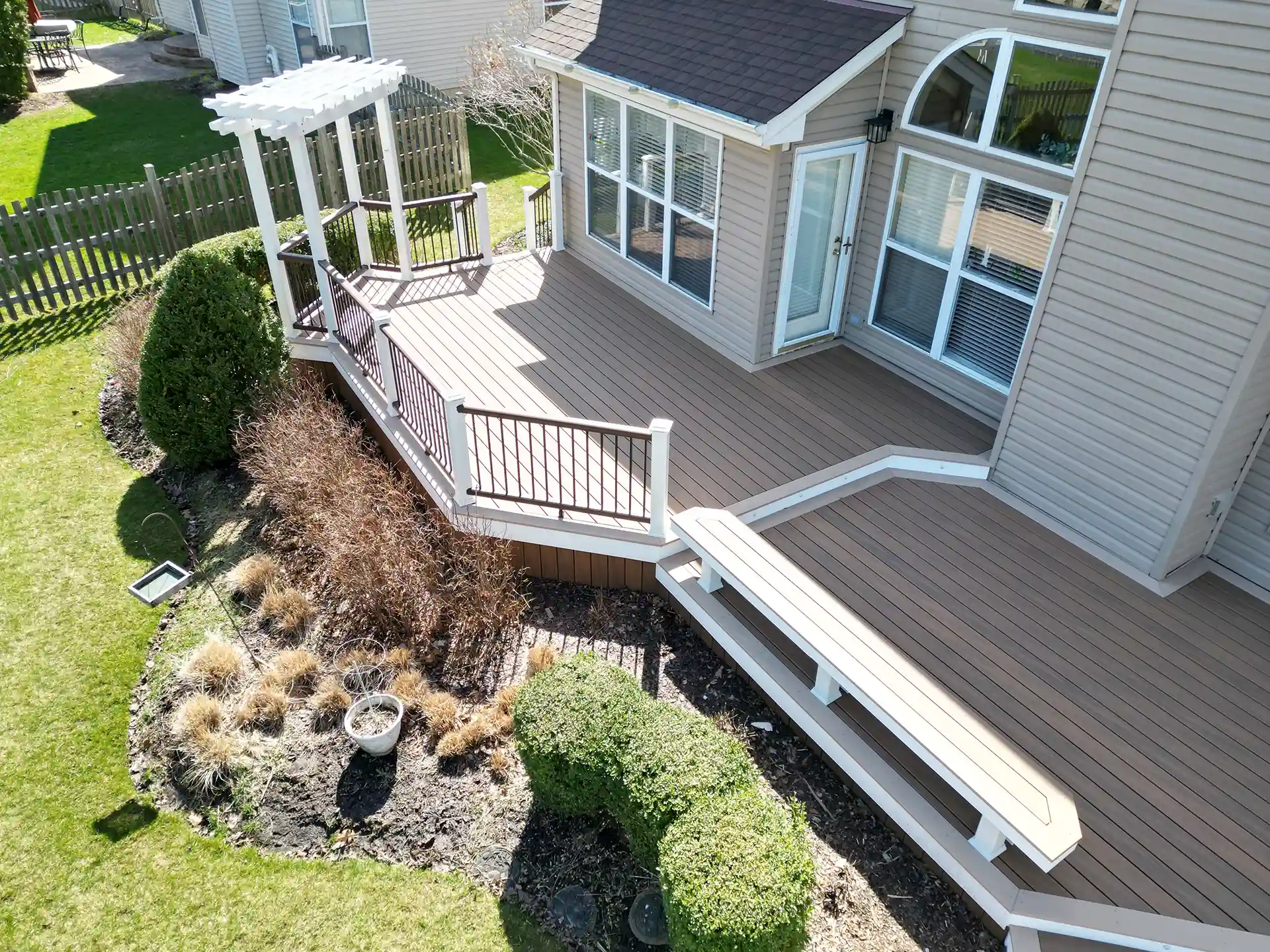 Photo of a multi-level deck with an angled overlook area, geometric designs, and a pergola