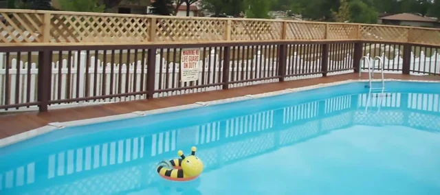 Photo of elevated pool deck with lattice privacy screen and dark wood railing.