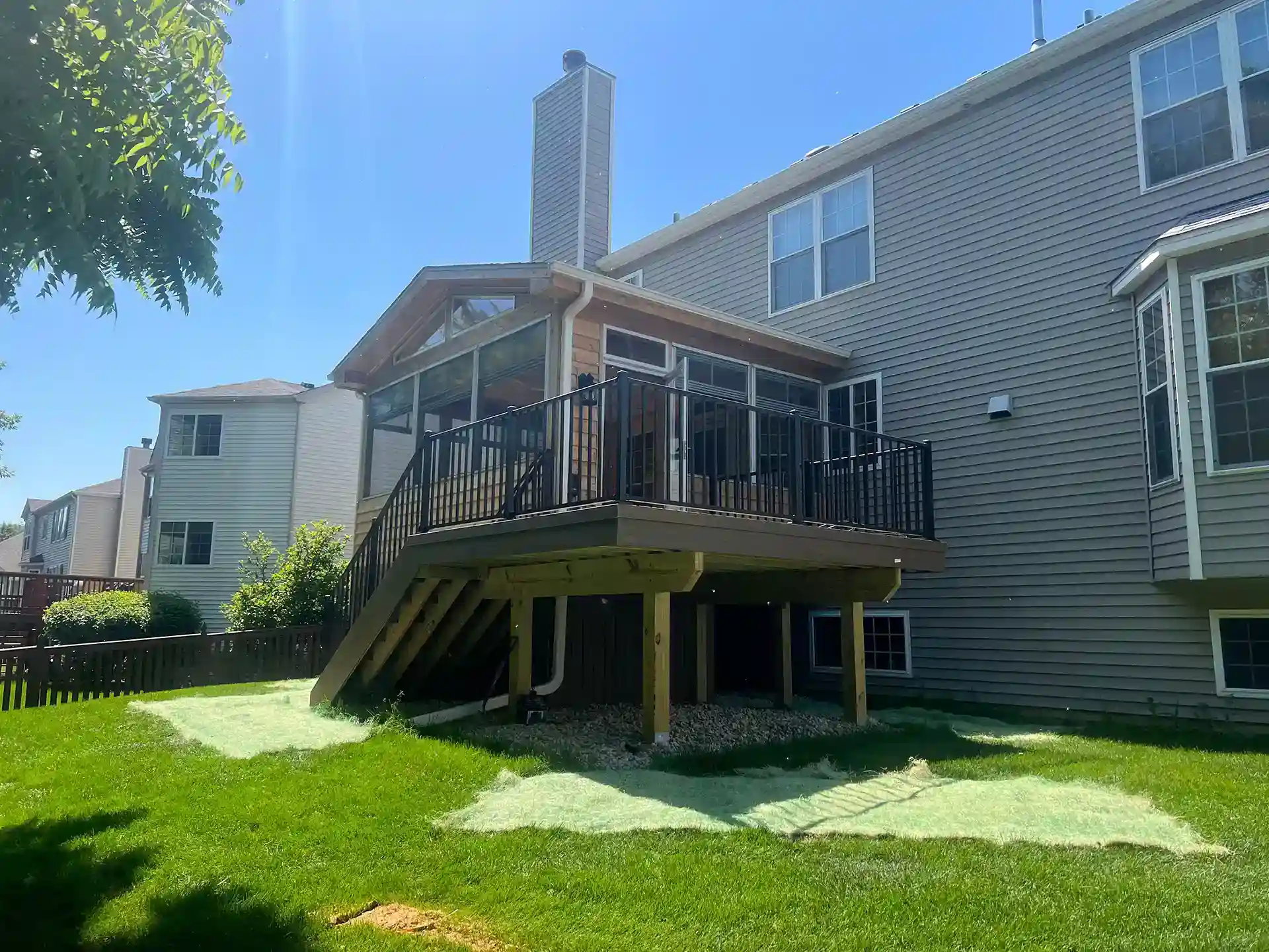 PHoto of a covered back porch with windows and screens
